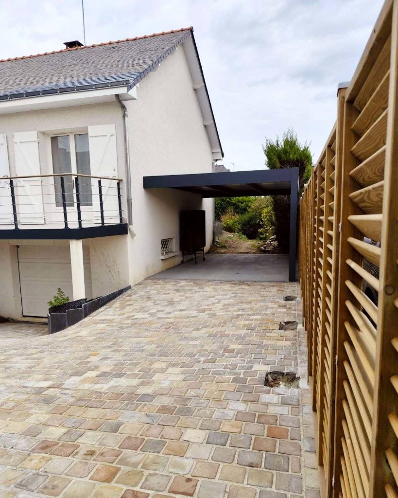 Vue sur un carport et une allée en pavage